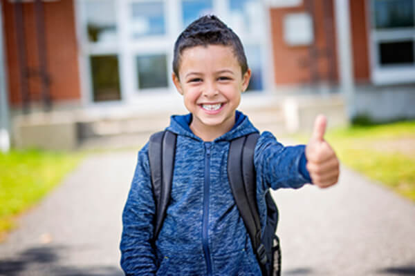 young boy going back to school, thumbs up