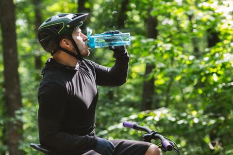 biking man is drinking water during summer to beat dehydration