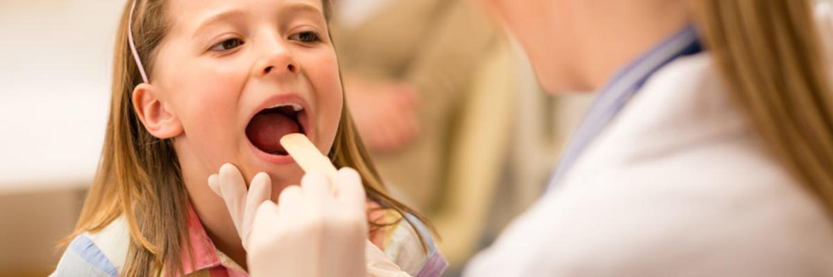 Young girl getting her throat checked by doctor, Ear, Nose & Throat