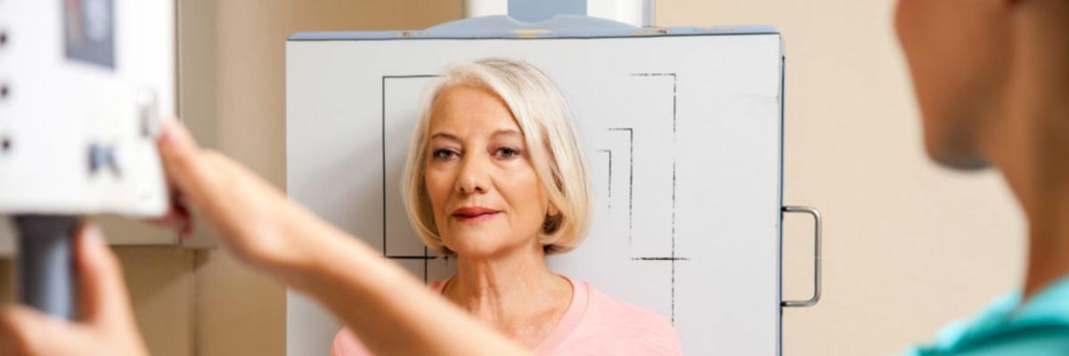 Mature woman getting an X-Ray, standing X-Ray exam
